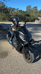 Toddler sits on scooter near Turkish bay
