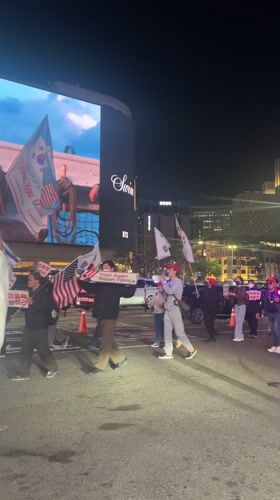 Night demonstration in Seoul features Korean-American flags, protest signs