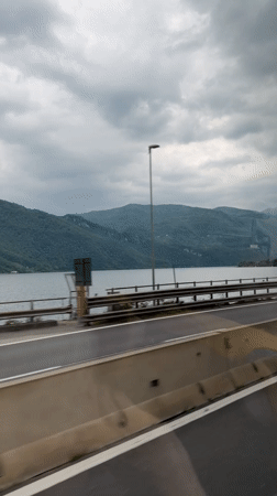 Morning highway travel recorded along lakeside road in Italy