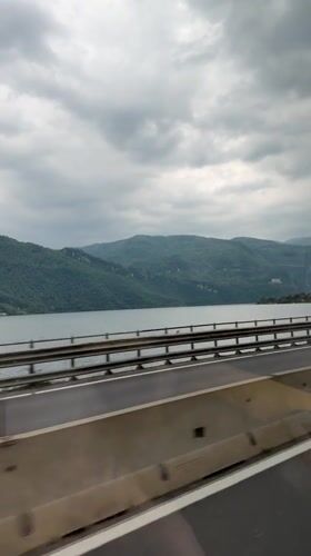 Morning highway travel recorded along lakeside road in Italy