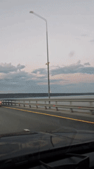 Evening traffic crosses bridge in Shali during sunset