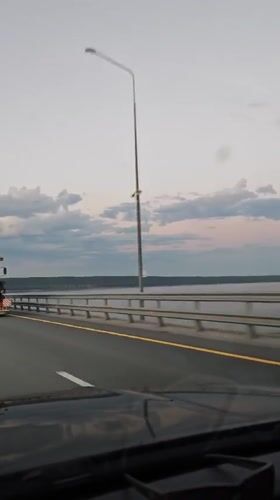 Evening traffic crosses bridge in Shali during sunset
