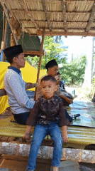 Gathering under a thatched roof in Aluekeutapang, Indonesia