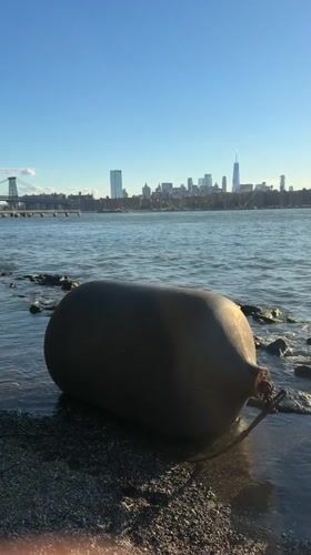Large fender washed up on a rocky New York shoreline