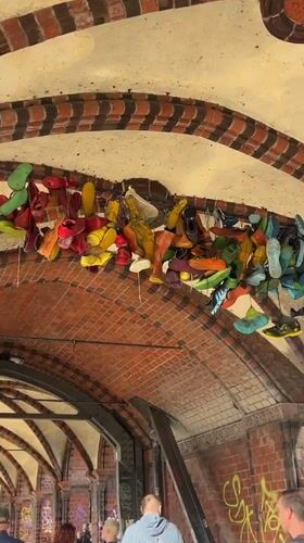 Suspended shoe art installation spotted under Berlin archway