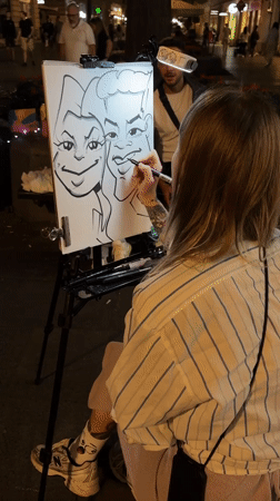 Street caricature artist at work on Belgrade pedestrian strip, night