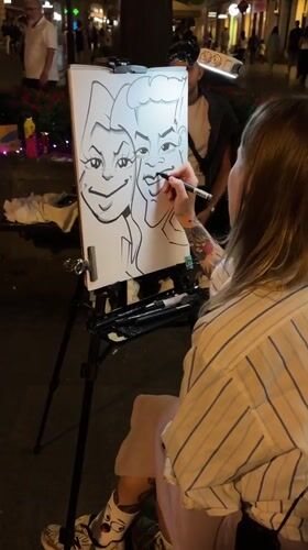 Street caricature artist at work on Belgrade pedestrian strip, night