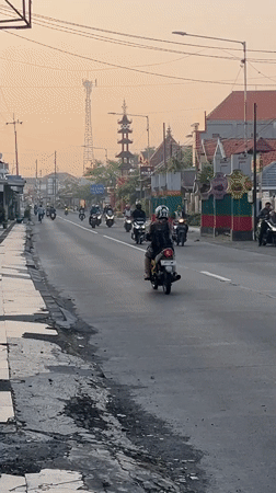 Rush hour traffic flows through East Java villages at dusk