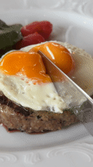 Runny egg yolk spills over a burger patty in Krasnoyarsk