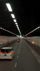 Vehicle travels through tunnel toward Nanshan District skyline