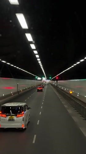 Vehicle travels through tunnel toward Nanshan District skyline