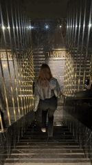 Woman descends marble stairs at undisclosed location