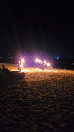Fire performers light up a Ko Samui beach at night
