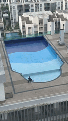 Early morning rooftop pool work, hazy Kuala Lumpur skyline documented