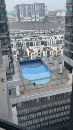 Early morning rooftop pool work, hazy Kuala Lumpur skyline documented