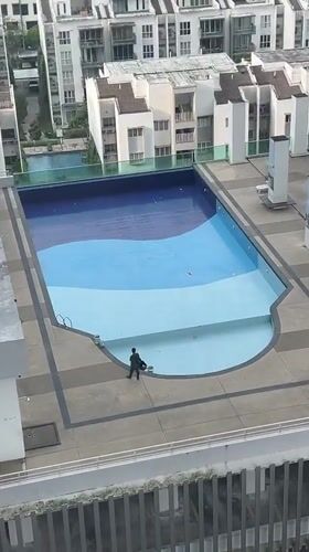 Early morning rooftop pool work, hazy Kuala Lumpur skyline documented