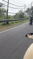 Motorcyclists ride through hilly terrain near Baturiti, Indonesia