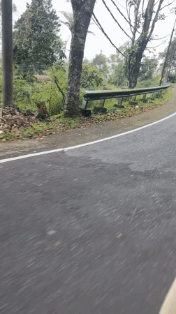 Motorcyclists ride through hilly terrain near Baturiti, Indonesia