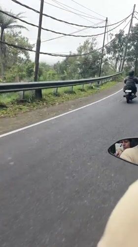 Motorcyclists ride through hilly terrain near Baturiti, Indonesia