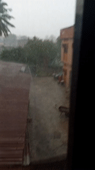 Heavy rainstorm drenches courtyard in tropical location