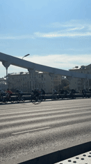 Cyclists ride in formation across a Moscow bridge