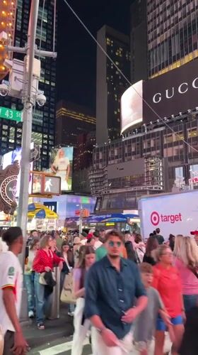 Late-night Midtown: Times Square crowds and rainbow-lit Empire State Building