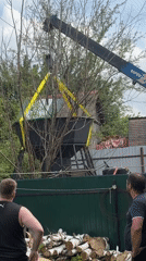 Crane removes water tower from residential backyard