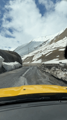 Vehicle navigates snowy mountain road and stone tunnel in Georgia