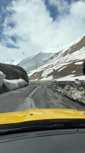 Vehicle navigates snowy mountain road and stone tunnel in Georgia