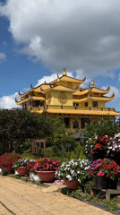 Robed figures load truck near ornate building in Da Lat