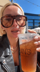 Woman enjoys iced drink at San Diego outdoor cafe