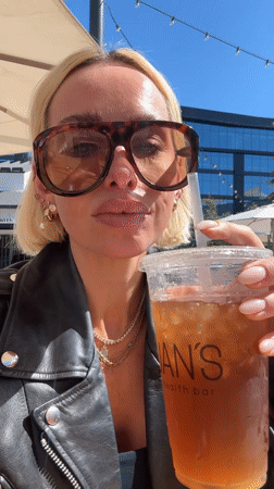 Woman enjoys iced drink at San Diego outdoor cafe