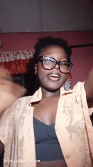 Selfie session in an Onitsha bedroom, orange shirt and glasses