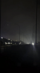 Nighttime road in Uyo, blue-lit building, misty streets