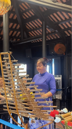 Woman plays traditional Vietnamese bamboo xylophone in Nha Trang