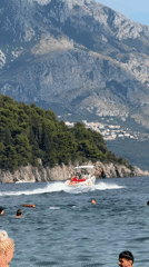 Swimming and speedboats off the Budva coast on a sunny afternoon