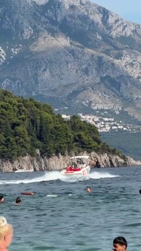 Swimming and speedboats off the Budva coast on a sunny afternoon