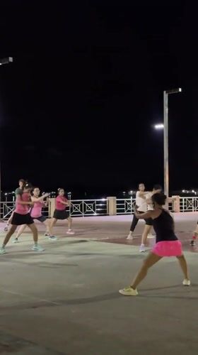 Night aerobics class on Surat Thani's riverside promenade