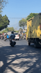 Morning traffic moves through Gelam streets with a directing hand