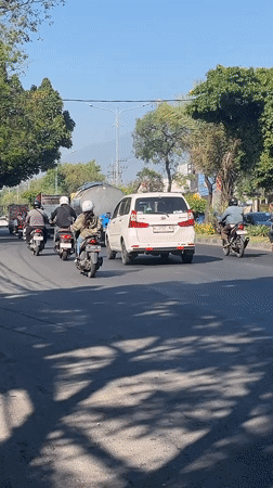 Morning traffic moves through Gelam streets with a directing hand