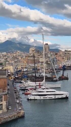 Aerial footage captures Genoa harbor with docked yachts, fire boat