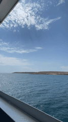 Boat approaches rocky Venezuelan coastline under partly cloudy skies