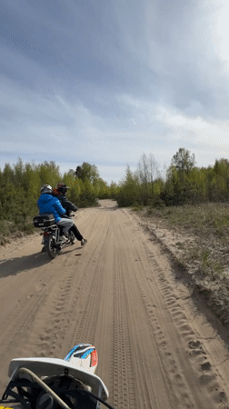 Motorcyclists ride sandy woodland trail near Dubrovka, Russia