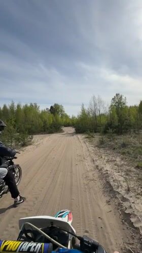 Motorcyclists ride sandy woodland trail near Dubrovka, Russia