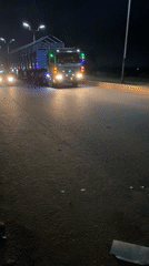Nighttime street activity and illuminated truck traffic in Bukuru