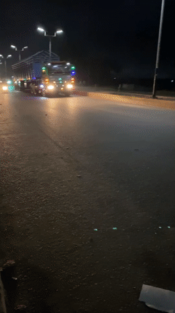 Nighttime street activity and illuminated truck traffic in Bukuru