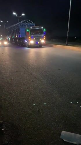 Nighttime street activity and illuminated truck traffic in Bukuru