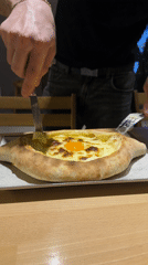 Man enjoys Georgian khachapuri dish at Barcelona restaurant