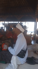 Balinese beachside temple ceremony with gamelan, offerings, and ritual dress