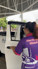 Woman exits pickup truck at Thai driving facility